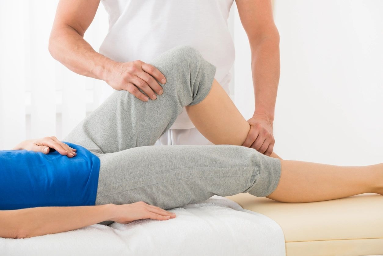 Physiotherapist assessing a patient's leg mobility